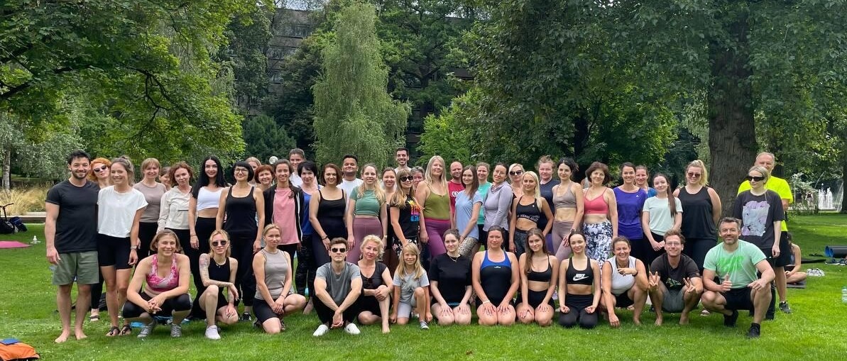 Große Gruppe von bis zu 80 Teilnehmenden bei kostenlosen Sportkursen im Stuttgarter Schlossgarten – Integration durch Bewegung, Yoga und Functional Training.
